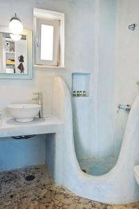 a white bathroom with a sink and a shower at Studio with Seaview at Faragas in Angairiá