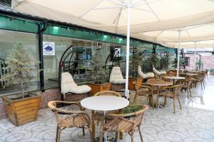 un restaurant avec des tables, des chaises et des parasols dans l'établissement Shahdag Quba & Truskavets, à Quba