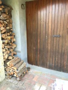 a wooden door next to a pile of fire wood at Villa in Toscana a due passi da Saturnia in San Giovanni delle Contee