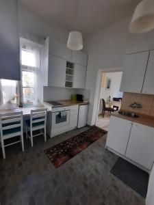 een keuken met witte kasten en een tafel met stoelen bij Apartmán Matty v tichom dvore priamo v centre in Bratislava