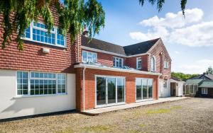 une maison en briques avec de grandes fenêtres dans l'établissement Croft House Sleeps 14 ꕤ Country Views nr Salisbury, à Salisbury