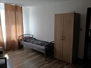 ein kleines Schlafzimmer mit einem Bett und einem Holzschrank in der Unterkunft Marktplatz Duisburg in Duisburg