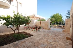 a patio with a table and chairs and an umbrella at La Piccola Corte in Alberobello