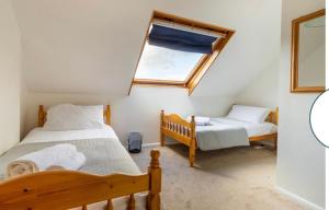 a bedroom with two beds and a window at Quayside in Wroxham