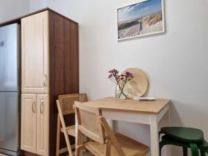 a kitchen with a table and chairs and a refrigerator at Apartament na Żeromskiego in Gdynia