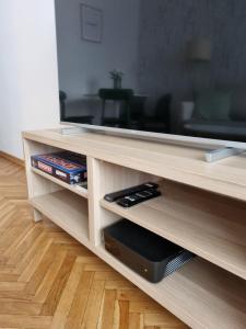 een houten entertainmentcentrum met een flatscreen-tv bij Apartament na Żeromskiego in Gdynia