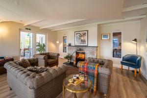 a living room with two couches and a fireplace at Newton Lodge in Unapool