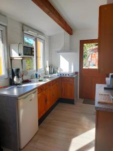 een keuken met houten kasten en een witte koelkast bij lovely apartment, gite, visit the vosges france in Fontenoy-le-Château