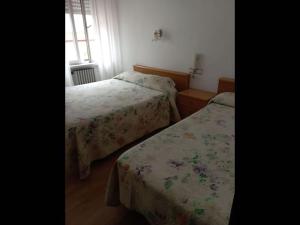 a bedroom with two beds and a window at Room in Lodge - Double and single room - Pension Oria 3 in Luarca
