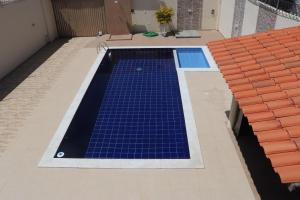 a swimming pool with blue tiles on a building at Casa abençoada in Barra de São Miguel