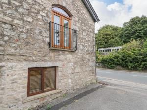 a stone building with a window on the side of a road at Coach House in Carnforth