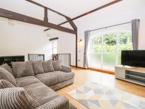 uma sala de estar com um sofá e uma televisão de ecrã plano em Coach House em Carnforth