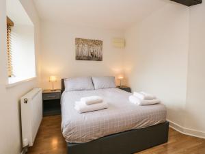 um quarto com uma cama com duas toalhas em Coach House em Carnforth