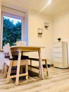 einen Tisch und Stühle in einem Zimmer mit Fenster in der Unterkunft Au petit canal de Bavilliers in Bavilliers