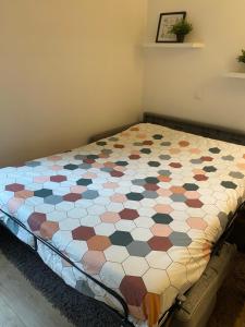a bed in a room with a quilt on it at Centre Saint-Gervais Studio Vert moderne 2 pers proche télécabine in Saint-Gervais-les-Bains