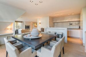 een keuken en eetkamer met een tafel en stoelen bij Luxe duplex villa8p in cottagestijl met wellness in Knokke-Heist