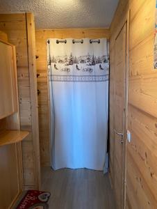 eine Dusche in einem Zimmer mit einem weißen Duschvorhang in der Unterkunft Studio magnifique saint Gervais les bains in Saint-Gervais-les-Bains