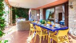 un tavolo blu e sedie gialle su un patio di CORAZZA 6&1, Emma Villas a Torri del Benaco
