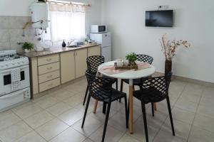 a kitchen with a table and chairs in a kitchen at Moana Alojamientos in Junín