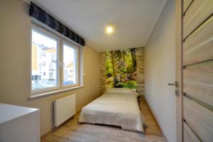 a room with two beds in it with a window at Apartamenty Sun Seasons 24 - Izery in Świeradów-Zdrój