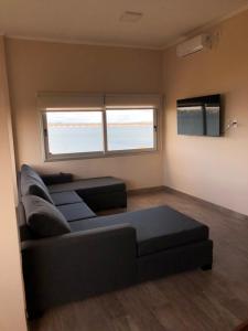 a living room with a couch and a large window at Edificio Itasu - 3ro - alquileres temporales in Posadas