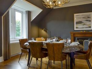 a dining room with a table and chairs and a chandelier at Darroch View in Ballater