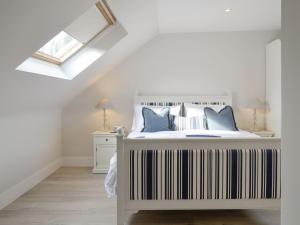 a white bedroom with a bed with a skylight at Darroch View in Ballater