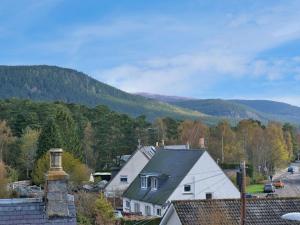 a white house with a mountain in the background at Darroch View in Ballater
