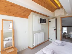 a bedroom with a bed and a tv on the wall at Top House in Forden