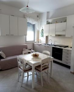 a kitchen and living room with a white table and chairs at Little House in San Salvo