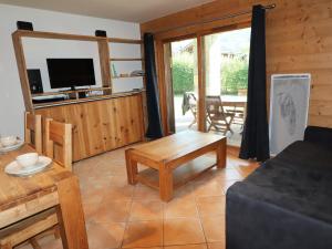 ein Wohnzimmer mit einem Sofa und einem TV in der Unterkunft Appartement Samoëns, 2 pièces, 5 personnes - FR-1-624-105 in Samoëns