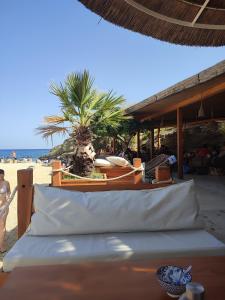 Ein Bett am Strand mit einer Palme im Hintergrund in der Unterkunft Maria GuestHouse in Aliveri