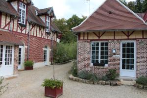 an old brick house with a driveway in front of it at L'écurie de Vieux-Moulin in Vieux-Moulin