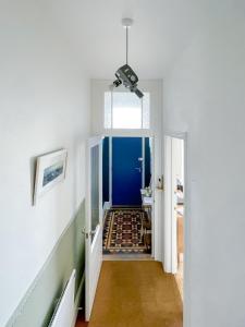 a hallway with blue walls and white walls at Sleeps 16 with style and space- and a hot tub! in Newquay