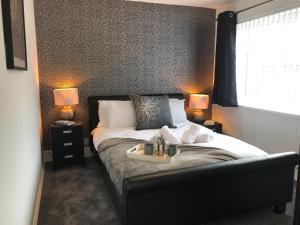 Un dormitorio con una cama y una bandeja. en Modern 3-bed house with parking Bamber Bridge, Preston, en Bamber Bridge