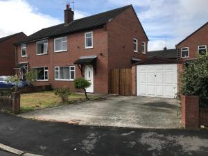 a brick house with a white garage at Modern 3-bed house with parking Bamber Bridge, Preston in Bamber Bridge