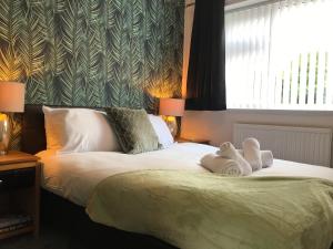 um quarto com 2 camas e toalhas em Modern 3-bed house with parking Bamber Bridge, Preston em Bamber Bridge