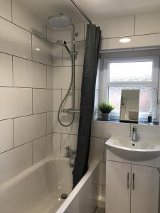 a bathroom with a bath tub and a sink at Modern 3-bed house with parking Bamber Bridge, Preston in Bamber Bridge