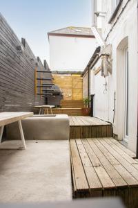 a patio with a bench and a table on a building at Sleeps 16 with style and space- and a hot tub! in Newquay