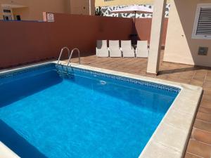 una piscina con sillas junto a un edificio en Casa Mariben, Vacation Rental home Vv 3 Bedrooms private pool with sea views, en Callao Salvaje