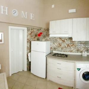 a kitchen with white cabinets and a white refrigerator at Appartamenti della Rotonda in Catania