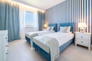 a bedroom with two beds and a window at Belle View - 3pok, nawet 5 łóżek, piękny widok na rzekę, TV55" z Netflix i Max, parking, winda in Iława