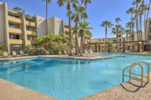 una gran piscina con sillas y palmeras en Chic Scottsdale Condo about 1 Mi to Old Town!, en Scottsdale