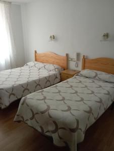 two beds sitting next to each other in a bedroom at Room in Lodge - Double and single room - Pension Oria 4 in Luarca