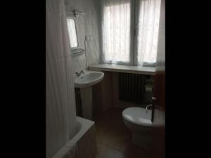łazienka z umywalką, toaletą i oknem w obiekcie Room in Lodge - Double and single room - Pension Oria 4 w mieście Luarca