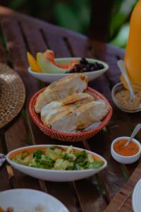 a table with plates of food and bowls of food at Quinta do Cajú in Ilha de Boipeba