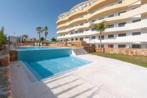 a swimming pool in front of a building at Premium Apartment with Swimming pool by Aparters in Arenales del Sol