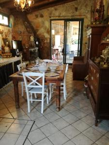 a kitchen with a wooden table with white chairs at Baglio Zio Ciccio in Altavilla Milicia