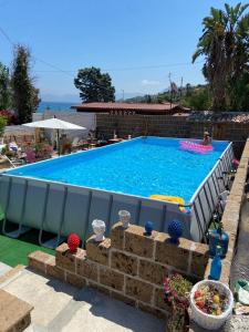a large swimming pool in a backyard with a person swimming at Baglio Zio Ciccio in Altavilla Milicia