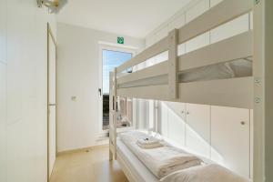 a bedroom with a bunk bed and a window at Penthouse app met imposant & eindeloos zeezicht in Middelkerke